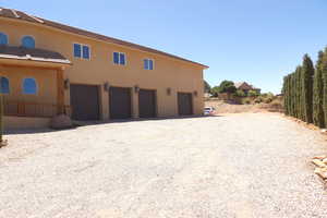 View of home's exterior featuring stucco siding, driveway, an attached garage, and a tiled roof