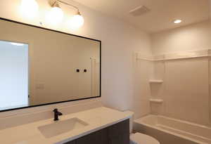 Bathroom featuring vanity, shower / bathtub combination, and recessed lighting
