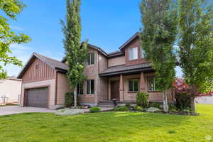 Craftsman inspired home featuring a front yard, a shingled roof, driveway, board and batten siding, and a porch