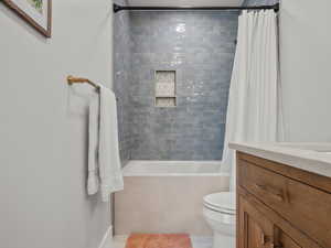 Bathroom with tiled shower / bath combo and vanity