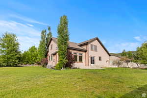 Back of property with a patio area and roof with shingles