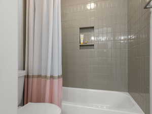 Full bathroom with shower / bath combination with curtain and toilet