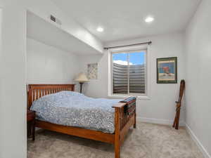 Bedroom with light carpet and recessed lighting