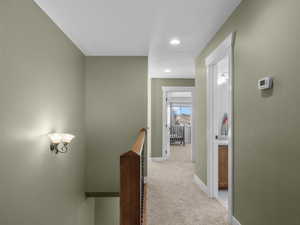 Hall featuring an upstairs landing, light colored carpet, and recessed lighting