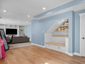 Recreation room with light wood-style floors, built in features, and recessed lighting