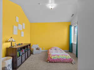 Bedroom featuring carpet floors and lofted ceiling