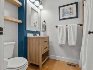 Bathroom with vanity, light tile patterned floors, and a shower with curtain