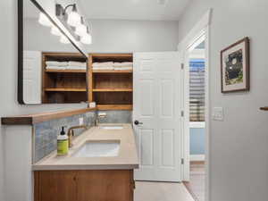 Full bathroom featuring decorative backsplash and double vanity