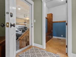 Corridor featuring light tile patterned floors and baseboards