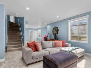Living room with stairway, carpet, and recessed lighting