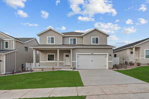 Two-story residence featuring a covered front porch, attached two-car garage, and a concrete driveway
