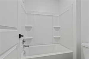 White acrylic bathtub and shower surround with integrated shelving