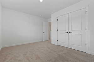 Bright interior space featuring light-toned carpeting and white walls