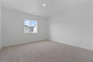 White-painted walls with recessed lighting, a single window, white trim, and neutral carpeting