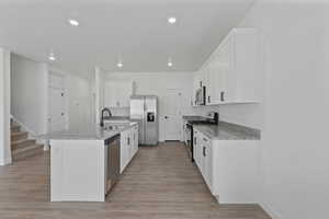 Modern kitchen featuring white cabinetry, granite countertops, and stainless steel appliances