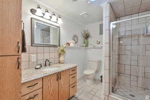 Bathroom with crown molding, a stall shower, vanity, light tile patterned floors, and decorative backsplash