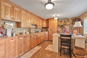 Kitchen with light brown cabinetry and light stone counters
