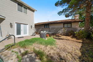 Rear view of house featuring a patio area, a chimney, and french doors