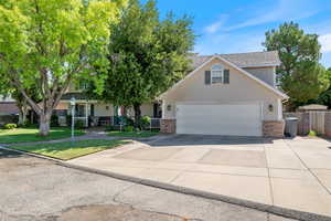 View of front of house featuring concrete driveway, a garage, and brick siding