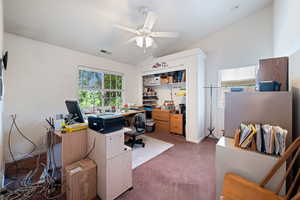 Home office with carpet flooring, healthy amount of natural light, lofted ceiling, and a ceiling fan