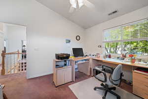 Office with vaulted ceiling, dark colored carpet, and ceiling fan