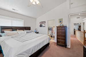 Carpeted bedroom with lofted ceiling, ceiling fan, and ensuite bathroom
