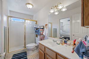 Ensuite bathroom with a shower stall, vanity, and a chandelier