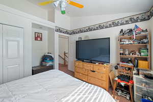Bedroom with vaulted ceiling, ceiling fan, and a closet