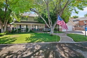 View of front facade featuring a porch, a garage, and driveway