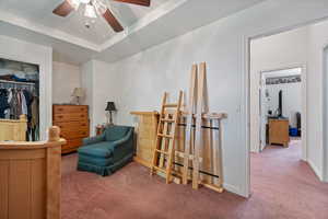 Bedroom featuring carpet flooring, ceiling fan, and a walk in closet