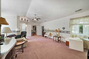 Sitting room featuring carpet floors, vaulted ceiling, and ceiling fan