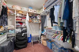 Walk in closet with dark carpet