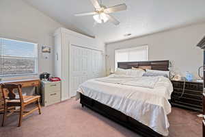 Bedroom featuring light carpet, lofted ceiling, ceiling fan, and a closet