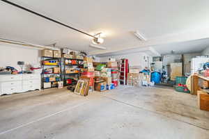 Garage featuring freestanding refrigerator, white fridge, and a garage door opener
