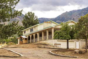 View of front of home featuring covered porch, a garage, a mountain view, and driveway