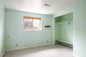 Unfurnished bedroom with carpet and a closet