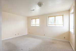 Empty room with plenty of natural light and carpet flooring
