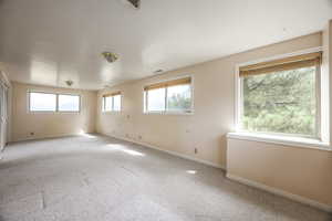 Spare room featuring carpet and baseboards