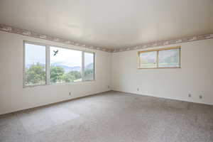 Empty room with a mountain view and carpet floors