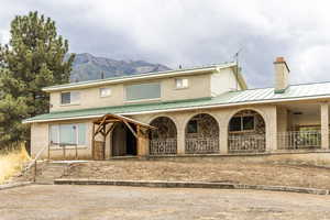 View of front of property featuring brick siding, covered porch, a metal roof, and a mountain view