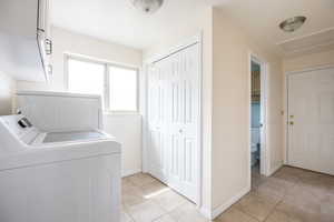 Laundry room featuring light tile patterned flooring and washing machine and dryer
