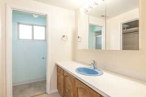 Full bathroom with vanity, light tile patterned floors, and a shower with door
