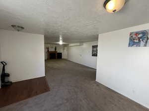 Below grade area with a textured ceiling, carpet flooring, and a fireplace