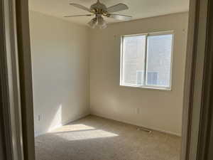 Empty room featuring carpet floors and ceiling fan