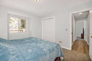 NEW Carpeted bedroom featuring a closet and baseboards