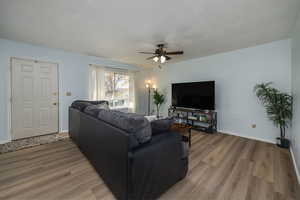 Living room featuring light wood-style flooring and a ceiling fan