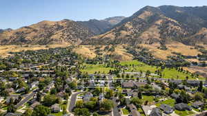 Aerial view of property and surrounding area featuring nearby suburban area and mountains