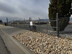 View of asphalt road with a gate and curbs