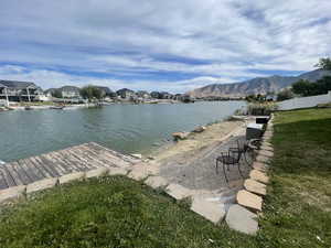 Private dock, sand and paver patio featuring views of the mountains.