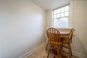 Dining area with light tile patterned floors and lofted ceiling